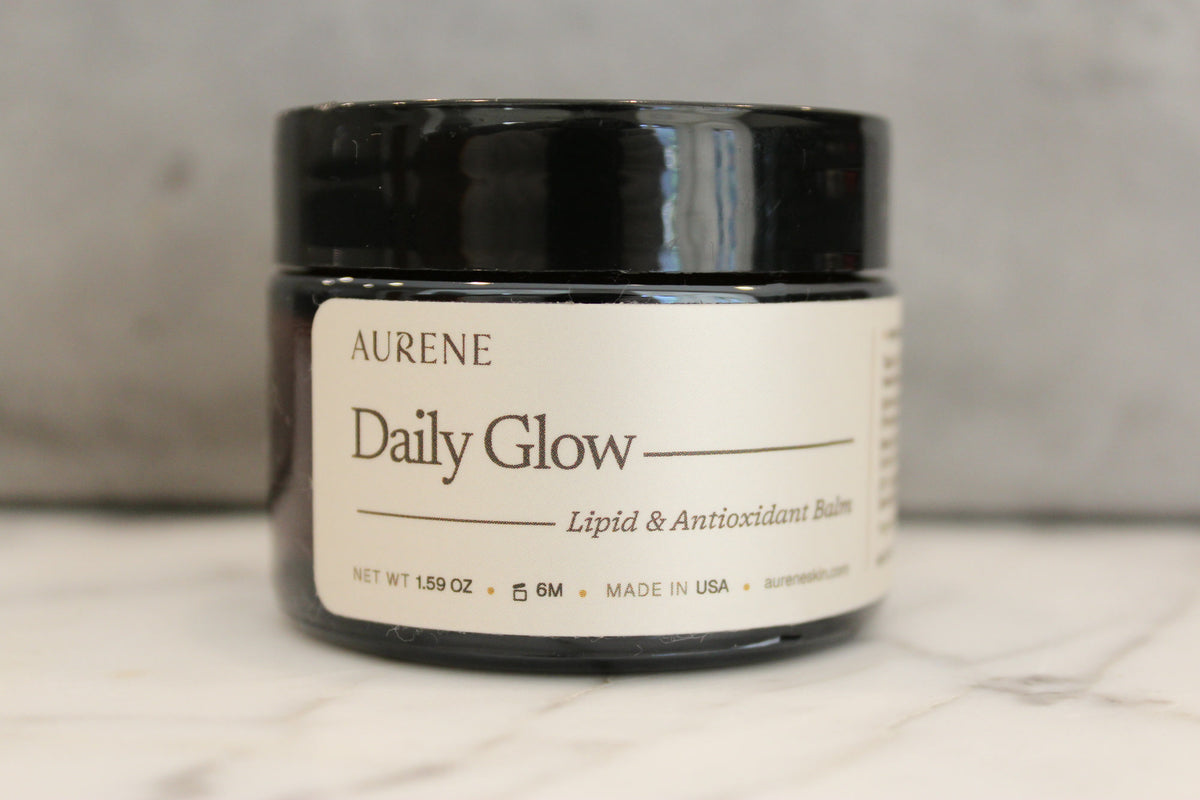 Daily Glow Lipid & Antioxidant Balm jar on white marble